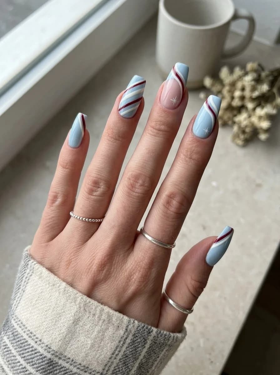 Light blue nails with red and white stripe accents and star accents