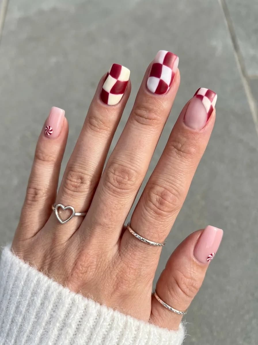 Nude nails with pink base red and white checkerboard accents candy cane accents