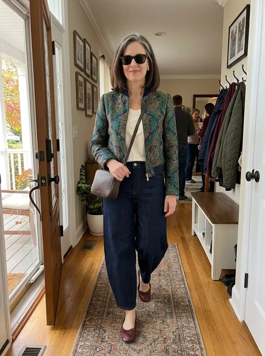 Cream tank top with green and blue patterned bomber jacket and dark-wash wide-leg jeans